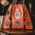 Orange bag with patches on a wooden surface